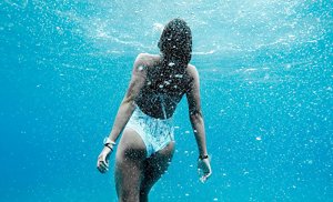 Woman in a white swimming costume swimming in the sea